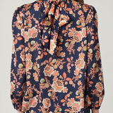 Woman wearing a floral blouse with a plain background