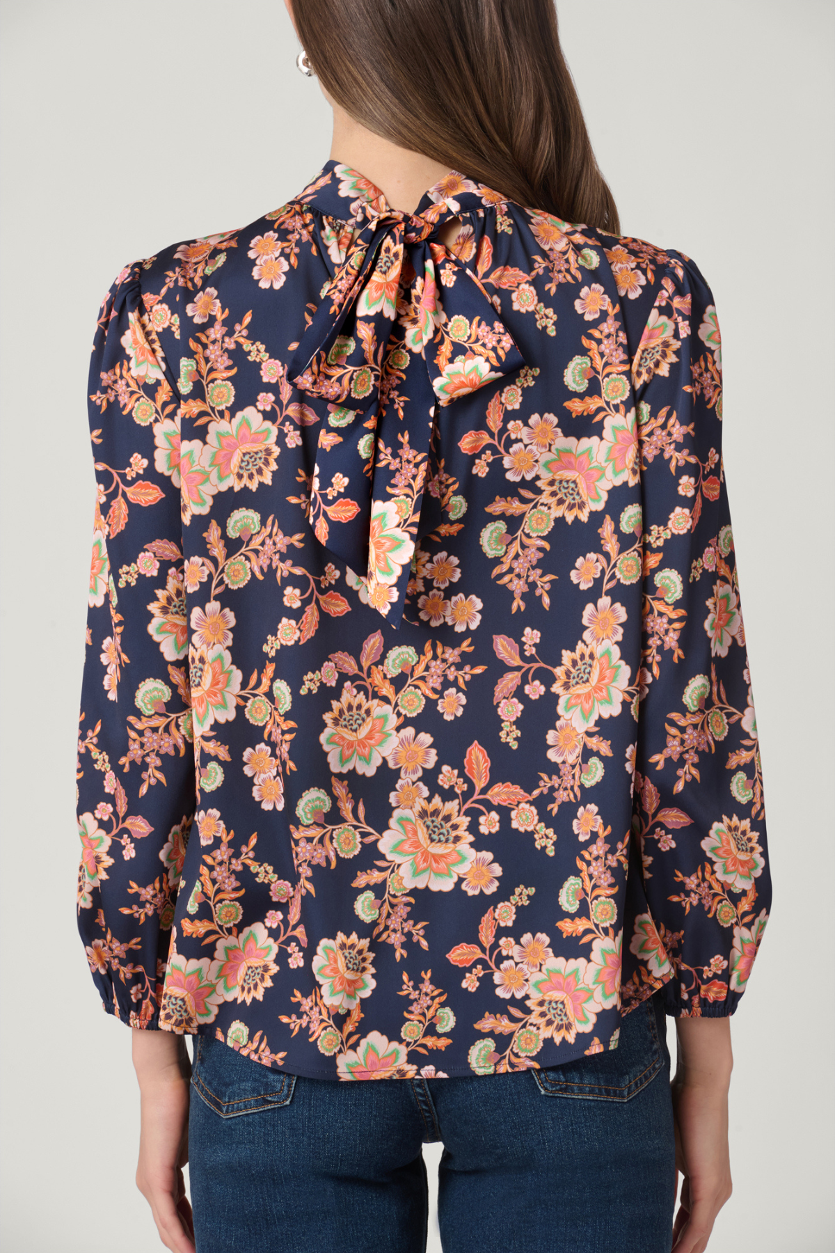 Woman wearing a floral blouse with a plain background