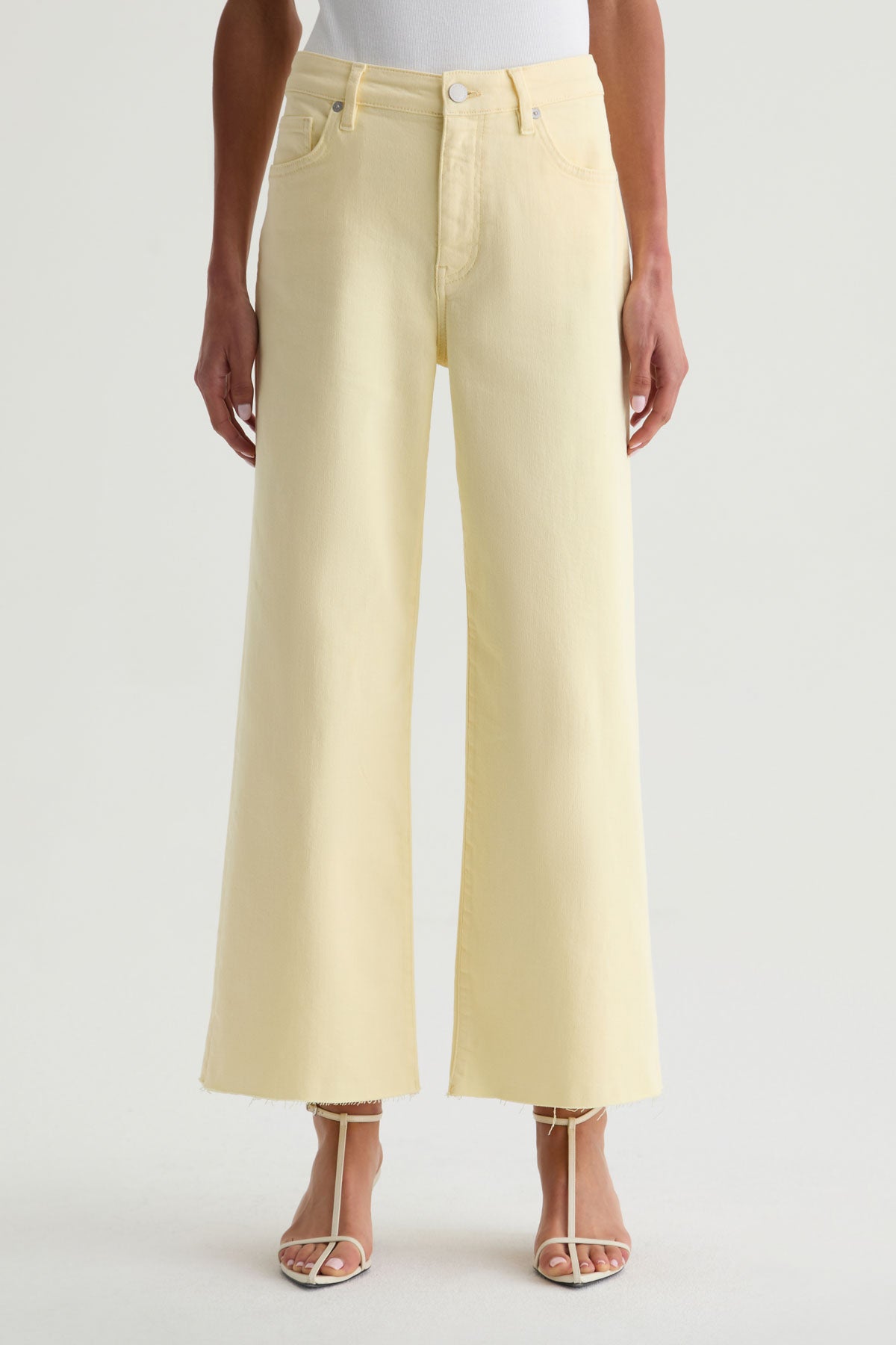 Light yellow jeans worn by a person on a white background