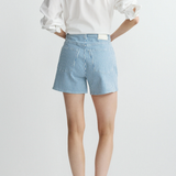 back of woman in stripe denim shorts on white background 