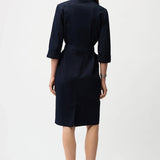 Woman wearing a indigo denim  dress with a belt on a white background