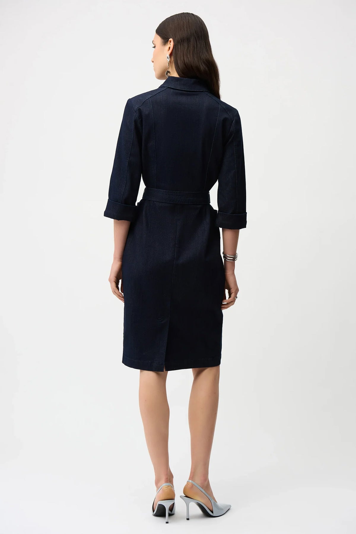 Woman wearing a indigo denim  dress with a belt on a white background