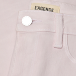 Close-up of a light pink garment with 'L'Agence' label and button detail.