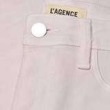Close-up of a light pink garment with 'L'Agence' label and button detail.