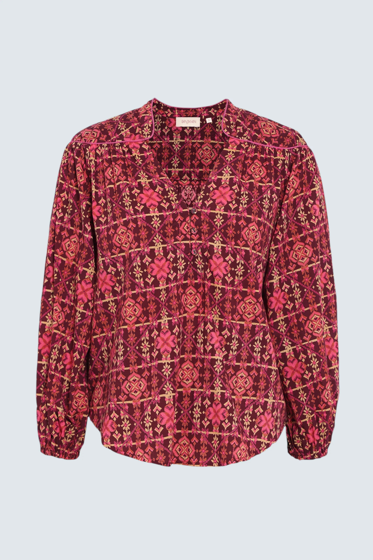 A long-sleeve blouse with a red, pink, and gold geometric pattern, displayed flat against a light gray background.