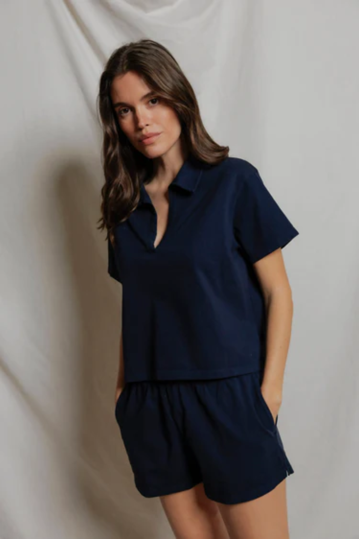 Woman wearing a navy blue outfit against a plain background