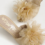 Beige high-heeled shoes with floral details on a white background