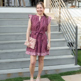 Woman in a patterned dress standing on outdoor steps