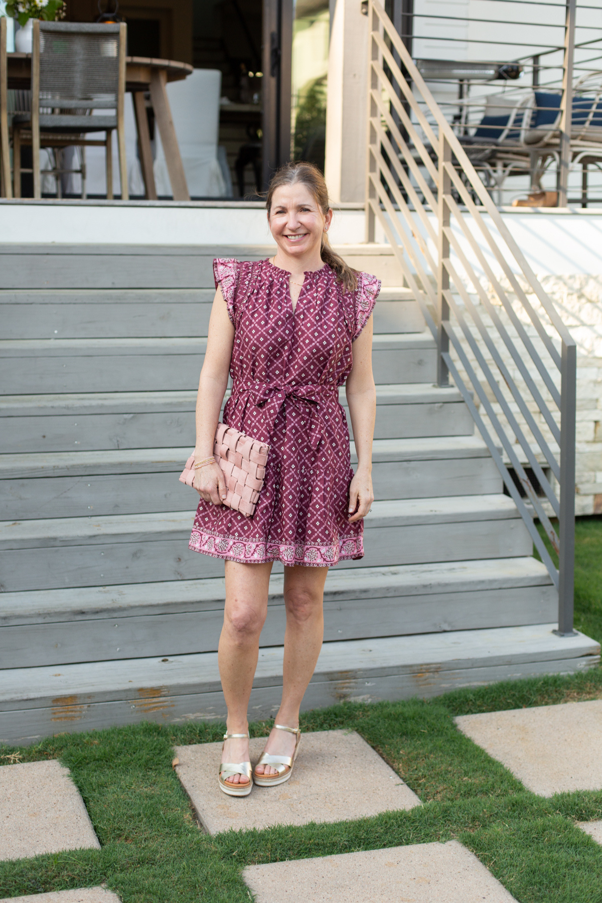 Woman in a patterned dress standing on outdoor steps