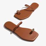 Pair of brown sandals with gold accents on a white background