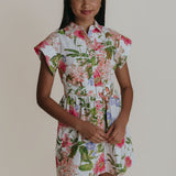 Woman wearing a floral dress against a plain background