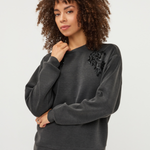 Women's gray modal sweater featuring long sleeves and decorative embellishment detailing.