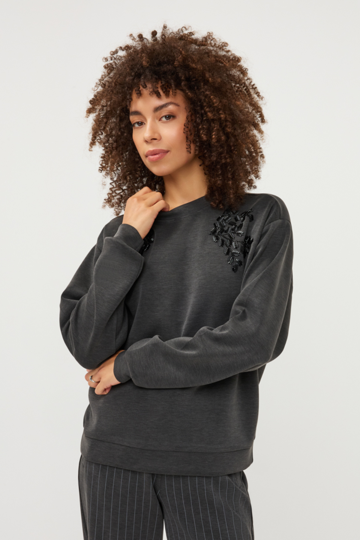 Women's gray modal sweater featuring long sleeves and decorative embellishment detailing.