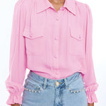 woman in pink long sleeve button down blouse on white background 