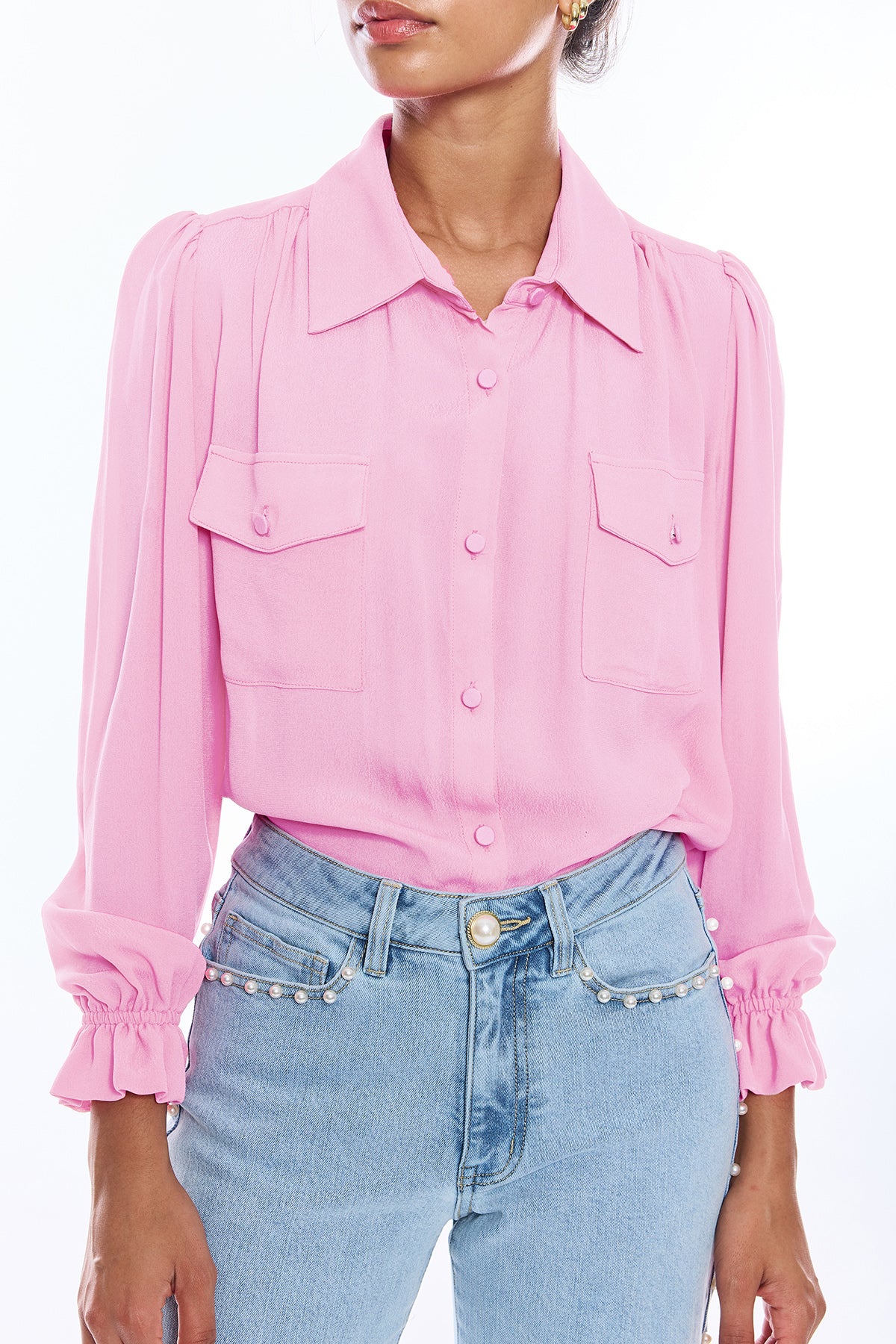 woman in pink long sleeve button down blouse on white background 