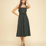 Woman wearing a black dress on a beige background