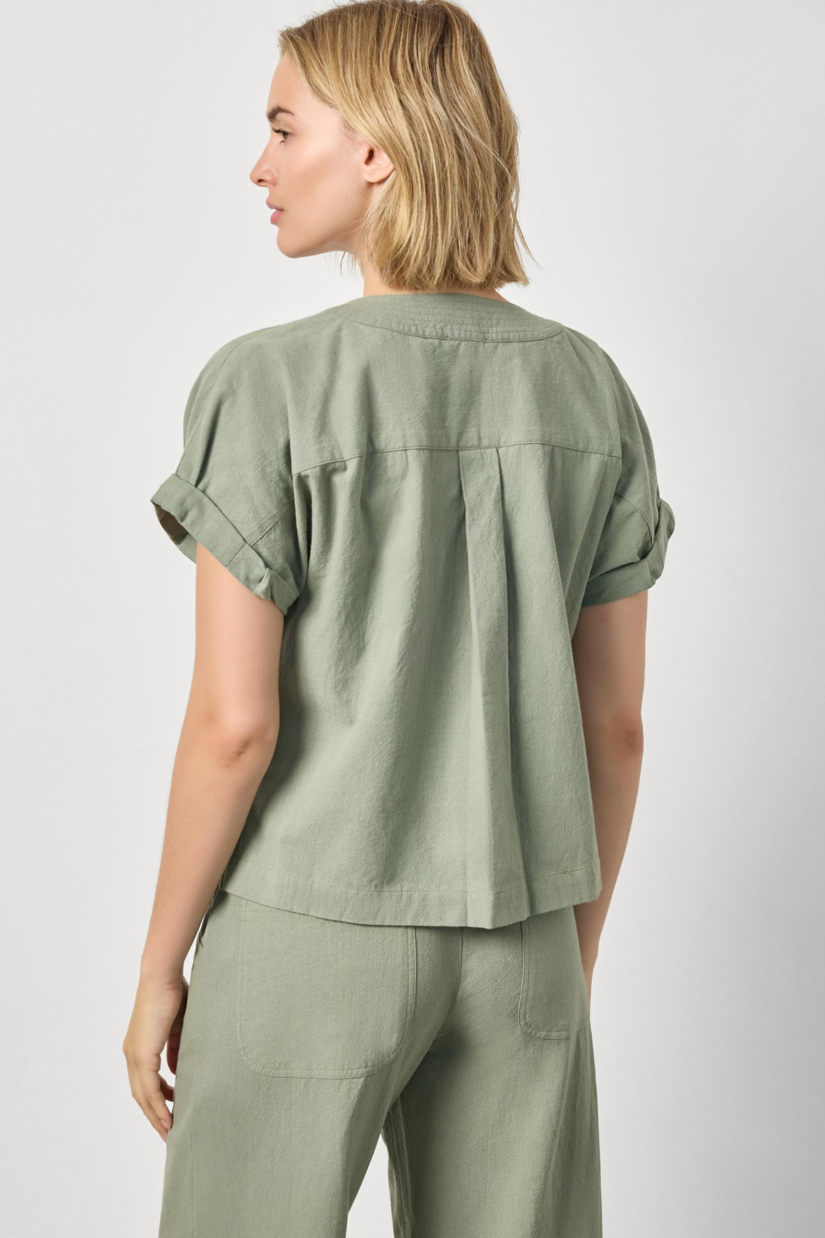 Woman wearing a green outfit on a white background