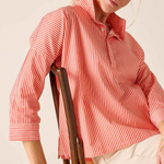 woman in striped button down sitting in chair 