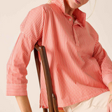 woman in striped button down sitting in chair 
