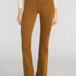 A model wearing a pair of brown corduroy flare pants with a cream knit top and black pointed-toe heels, shown from the chest down against a light gray studio background.
