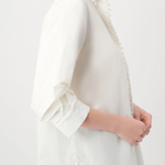 White blouse with ruffled sleeves worn by a person on a white background