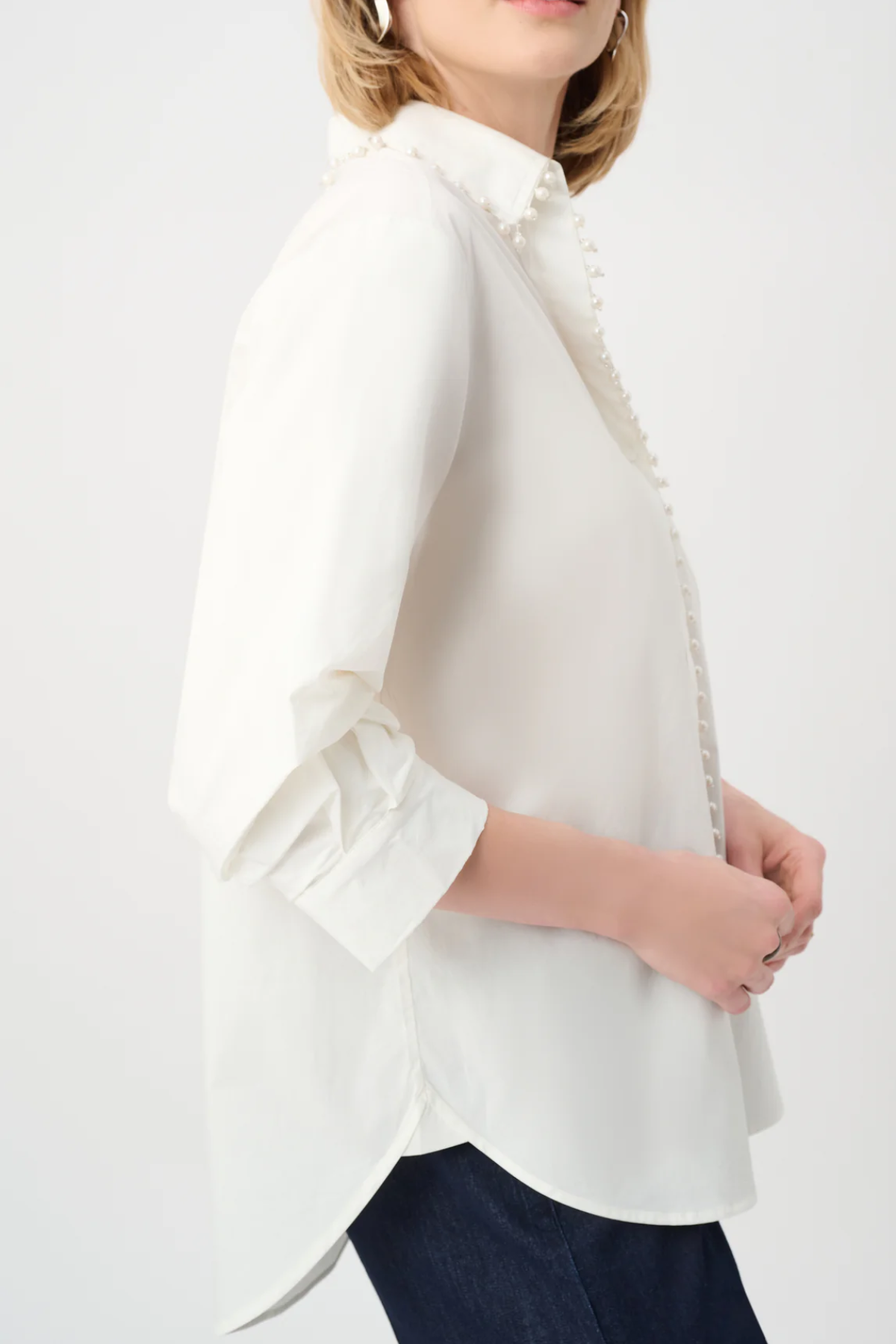 White blouse with ruffled sleeves worn by a person on a white background