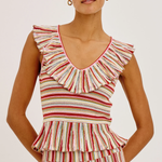 Woman wearing a striped sleeveless top with ruffled details on a white background