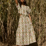 Woman in a floral dress standing in front of a natural background