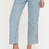 Light blue jeans with floral side panels worn by a person on a white background