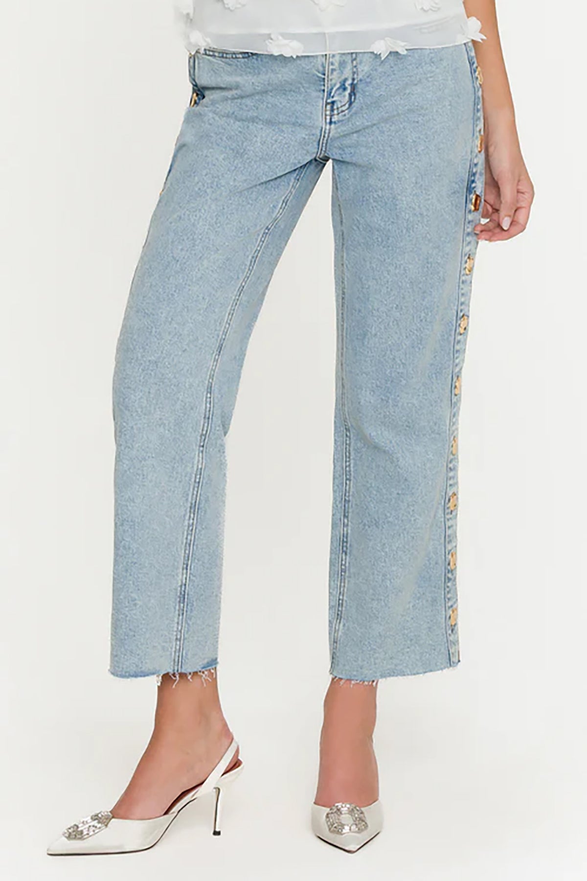 Light blue jeans with floral side panels worn by a person on a white background