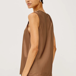 A woman modeling a sleeveless taupe-brown satin top, shown from a side-back angle against a clean light gray studio background.
