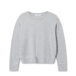 Woman wearing a light grey long-sleeve knit top with a relaxed fit, photographed against a soft neutral backdrop.