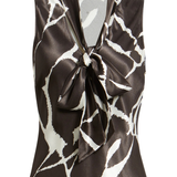 A sleeveless satin blouse with a brown and white abstract pattern, featuring a wrap-style collar with a large front bow, shown on a plain white background.