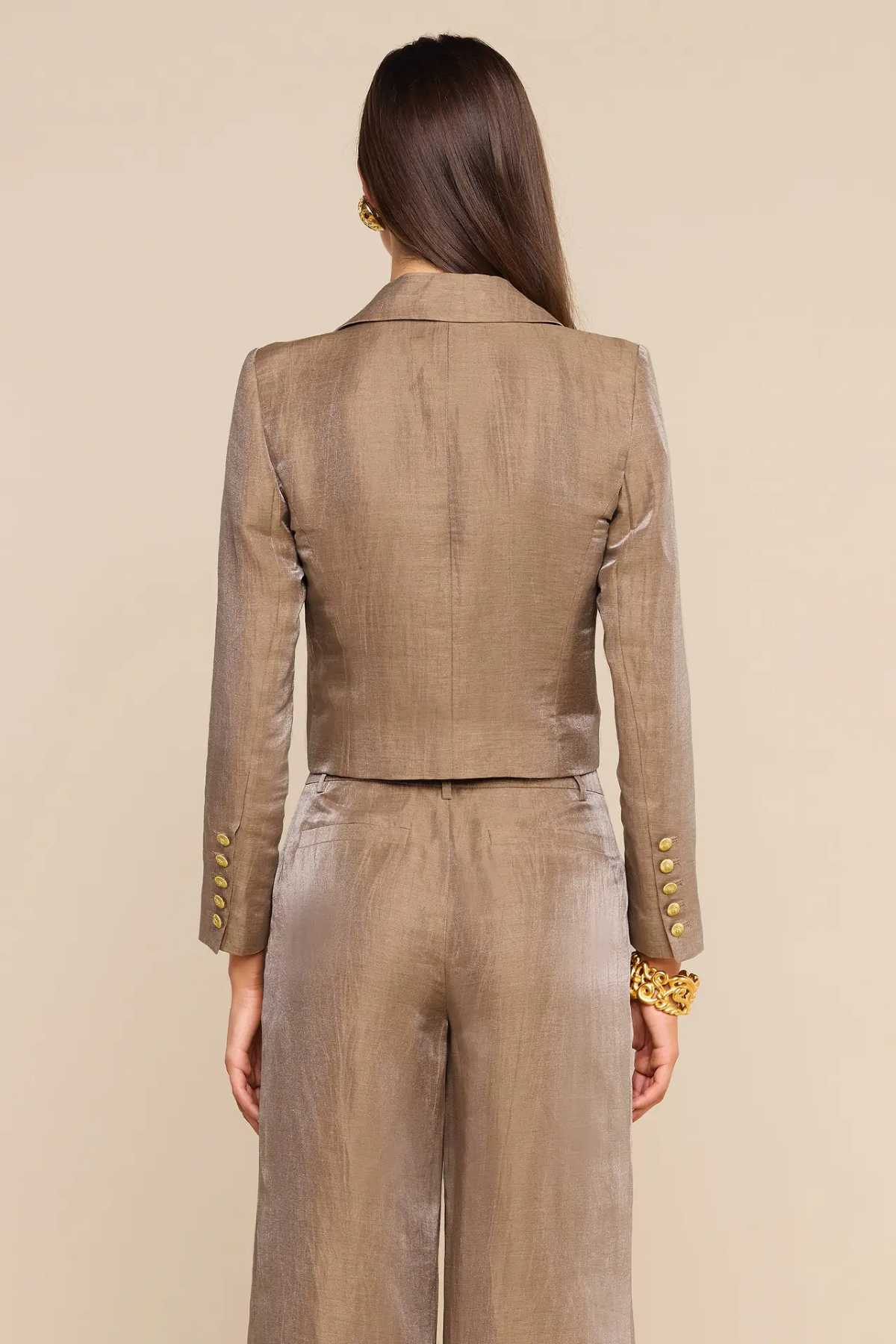 Women's cropped blazer in a warm neutral hue featuring long sleeves, tailored lapels, and a structured silhouette.