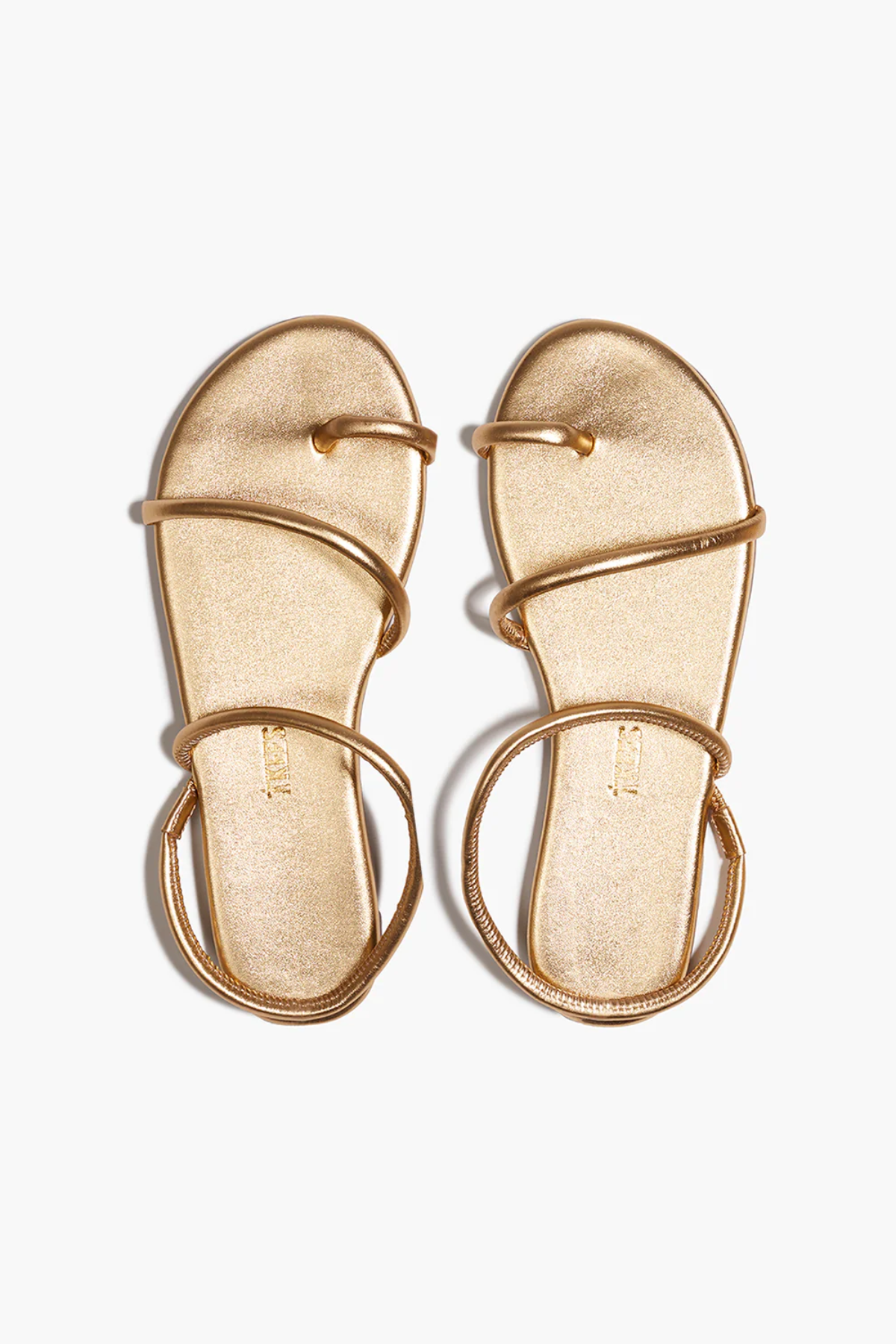 Pair of gold sandals on a white background