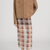 Person wearing a brown jacket and plaid skirt on a white background