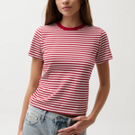 Woman wearing a red and white striped shirt with blue jeans on a plain background