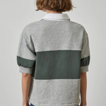 Person wearing a gray and green striped shirt with a plain background