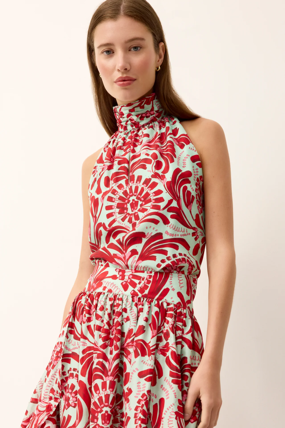 Woman wearing a red and white patterned dress against a plain background