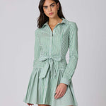 Woman wearing a green and white striped dress against a plain background