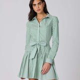 Woman wearing a green and white striped dress against a plain background