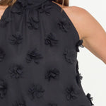 Black floral top worn by a model on a white background