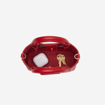 Small structured red tote bag with dual top handles and a compact, polished silhouette.