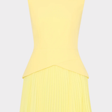 Yellow sleeveless dress with pleated skirt on a light gray background