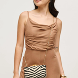 Woman in a brown outfit holding a zebra-striped handbag against a plain background