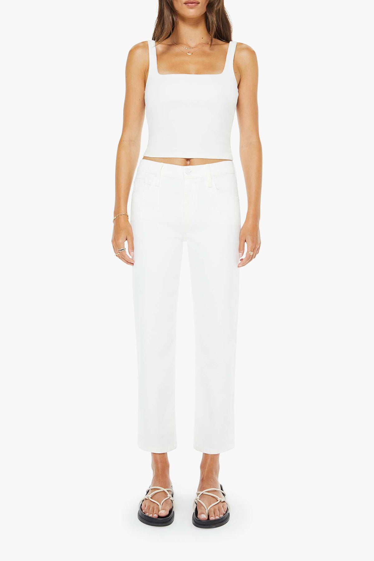 Woman wearing a white sleeveless top and pants on a white background