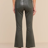 A model shown from the back wearing olive green faux-leather flare pants, a black belt, a black top, and black high heels against a solid beige background.