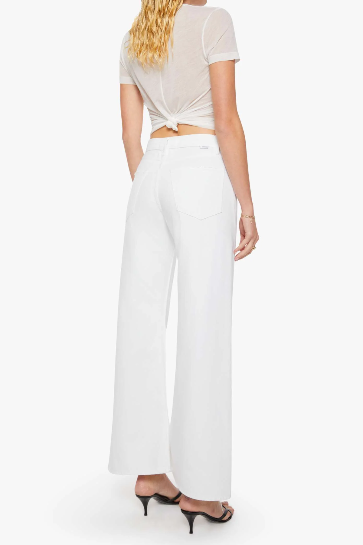 back of woman in white outfit on white background 