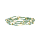 Green beaded bracelet with gold accents on a white background