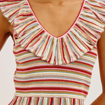 Woman wearing a striped sleeveless top with ruffled details on a white background